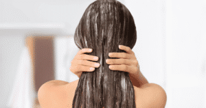 Clienta de espaldas experimentando el tratamiento de spa capilar japonés en los salones de Iván Senent, con el producto aplicado en el cabello, disfrutando del proceso de bienestar.